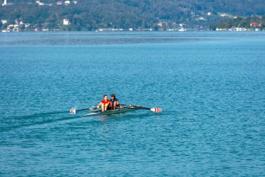 Worthersee, Avusturya-Ağustos 08, 2018: göl ve genç insanlar kürek sporu yapan tekne görünümü.