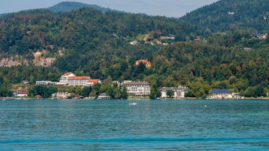 Worthersee, Avusturya - 08 Ağustos 2018: Tekne görünümünden göl ve kıyı şeridi. Yerel halk ve turistler teknelere tarafından tahrik yüzmek ve su eğlence diğer formları kullanmak.
