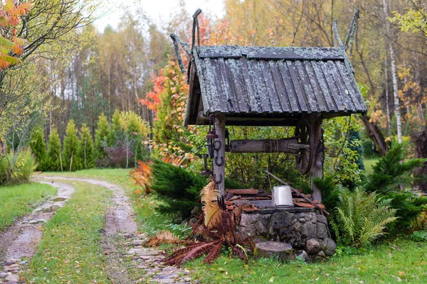 Storico pozzo con un cortile in legno tetto agriturismo . — Foto Stock