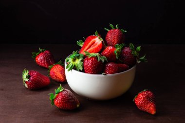 Koyu ahşap arka plan üzerinde seramik kase taze çilek. Se