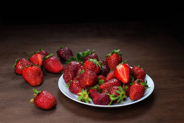 Fresh strawberries in ceramic bowl on dark wooden background. Se — Stock Photo, Image