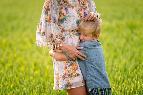 Eine Frau mit ihrem Sohn umarmte liebevoll das Getreidefeld. — Stockfoto