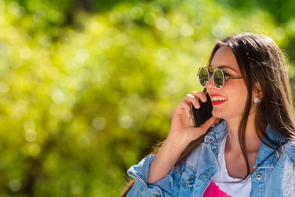 Belle, émotionnelle, jeune femme en lunettes de soleil parlant au téléphone. Fond doux. Espace de copie . — Photo