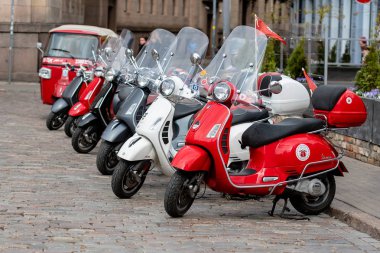 RIGA, LATVIA - 4 Mayıs 2019: Şehrin merkez meydanına park edilmiş klasik Vespa scooter sırası