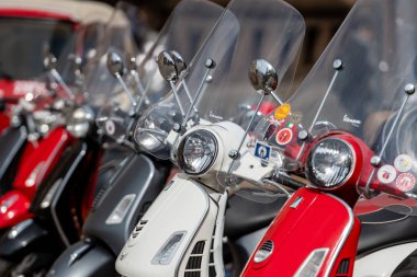 RIGA, LATVIA - 4 Mayıs 2019: Şehrin merkez meydanına park edilmiş klasik Vespa scooter sırası.