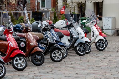 RIGA, LATVIA - 4 Mayıs 2019: Şehrin merkez meydanına park edilmiş klasik Vespa scooter sırası.