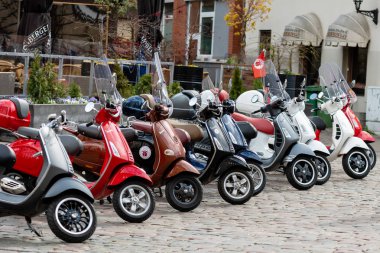 RIGA, LATVIA - 4 Mayıs 2019: Şehrin merkez meydanına park edilmiş klasik Vespa scooter sırası.