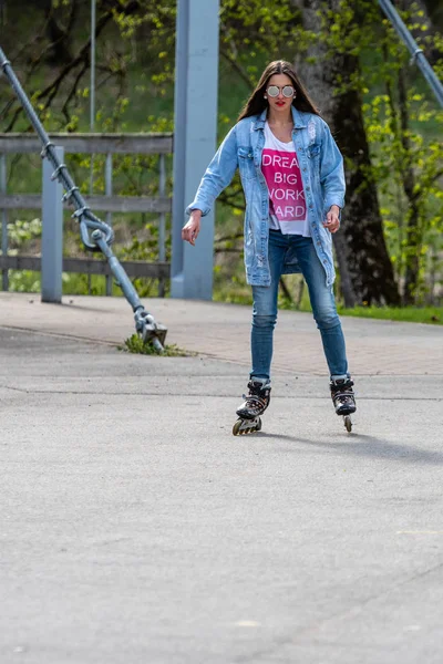 DOBELE, Letonia, - 7 de mayo de 2019: Una joven con gafas de sol en patines . — Foto de Stock