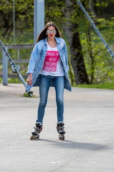 DOBELE, Letonia, - 7 de mayo de 2019: Una joven con gafas de sol en patines . — Foto de Stock