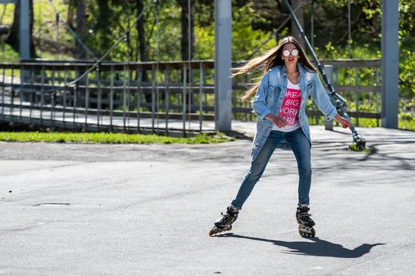 DOBELE, Letonia, - 7 de mayo de 2019: Una joven con gafas de sol en patines . — Foto de Stock