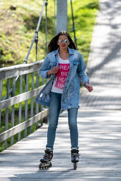 DOBELE, Letonia, - 7 de mayo de 2019: Una joven con gafas de sol en patines . — Foto de Stock