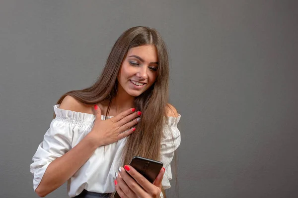 Mujer joven sonriente usando aplicaciones de teléfonos celulares, aspecto femenino atractivo — Foto de Stock