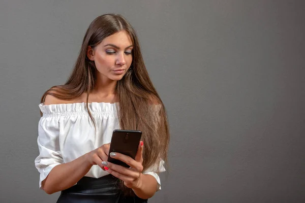 Photo d'une femme souriante aux longs cheveux foncés tenant et utilisant bl — Photo