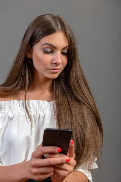 Foto de una mujer sonriente con el pelo largo y oscuro sosteniendo y usando bl — Foto de Stock