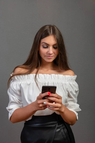 Foto de una mujer sonriente con el pelo largo y oscuro sosteniendo y usando bla — Foto de Stock