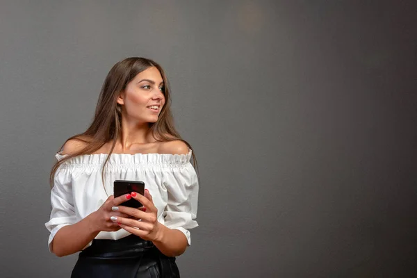 Uzun koyu saçlı gülümseyen kadının bla'yı tutarak ve kullanan fotoğrafı