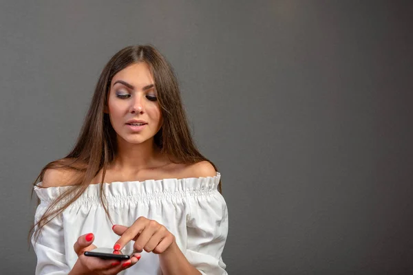 Photo d'une femme souriante aux longs cheveux foncés tenant et utilisant bla — Photo