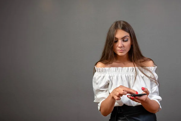 Foto de una mujer sonriente con el pelo largo y oscuro sosteniendo y usando bla — Foto de Stock