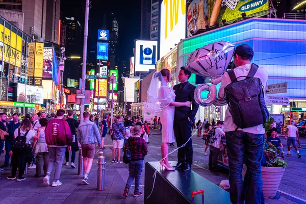 Nueva York, Estados Unidos - 21 de junio de 2019: multitudes de personas y recién casados a la luz de la noche en Times Square . —  Fotos de Stock