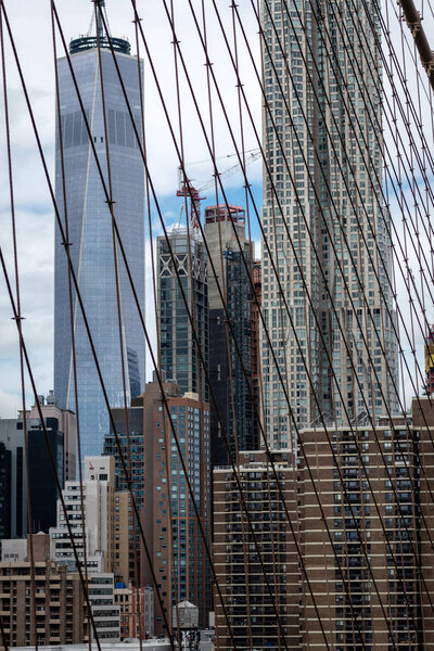 New York, USA - June 21, 2019: Manhattan through the Brooklyn Bridge metal ropes.