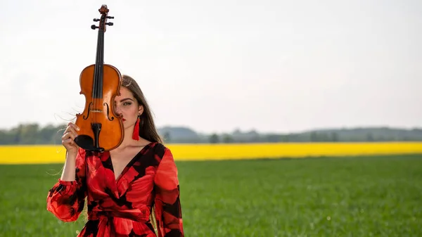 Retrato de una joven positiva. Parte de la cara está cubierta por el cuello del violín . — Foto de Stock