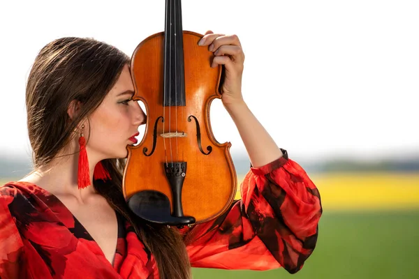 Retrato de una joven positiva. Parte de la cara está cubierta por el cuello del violín . — Foto de Stock