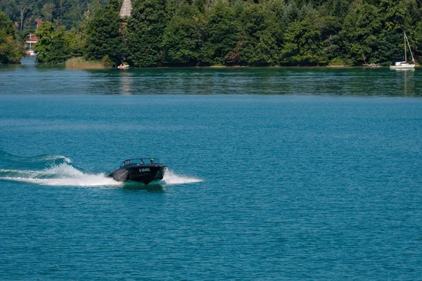 Worthersee, Österreich - 08. August 2018: Blick vom Boot auf See und Küste. Einheimische und Touristen schwimmen, fahren mit Motorbooten und nutzen andere Formen der Wassererholung. — Stockfoto