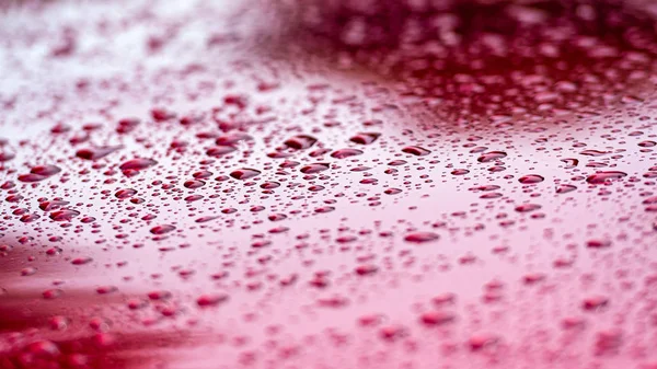 Ένα κοντινό προς τα σταγονίδια νερού σε ένα κόκκινο αμάξωμα-εικόνα — Φωτογραφία Αρχείου