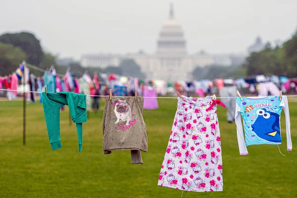 Вашингтон, округ Колумбия, США - 9 июня 2019 года: Защита от разлучения семей. Символические стиральные шнуры с детской одеждой рядом с зданием Капитолия . — стоковое фото