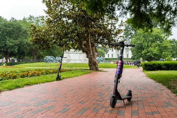 Washington DC, EUA - 9 de junho de 2019: Um scooter elétrico alugado está estacionado no parque na Praça Lafayette, em Washington, em um dia chuvoso . — Fotografia de Stock