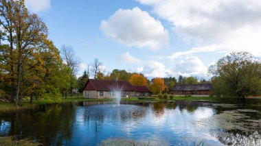 Luznava, Letonya, gölet ve çeşme ile Sonbahar manzara.