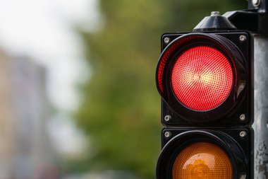 Odaklanmamış bir şehir arka planında dur ışığı olan trafik denetimi simgesi