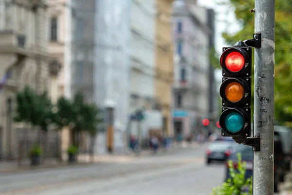 traffic control semaphore with stop light on a defocused city background