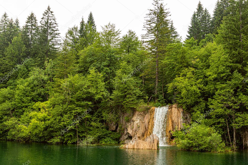 Beautiful waterfall and blue limpid lake in Plitvice Lakes National Park, Dalmatia, Croatia