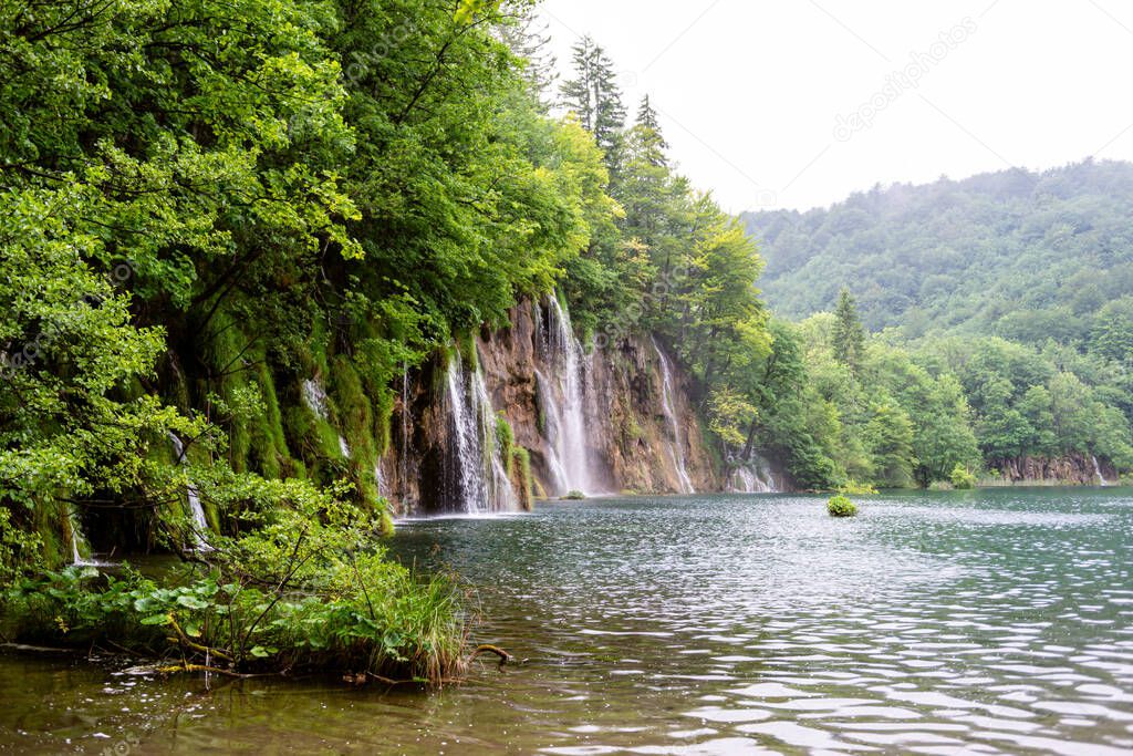 Beautiful waterfall and blue limpid lake in Plitvice Lakes National Park, Dalmatia, Croatia