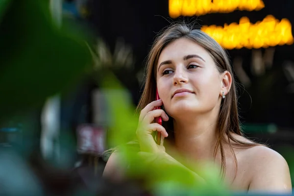 Sokak Kafesinde Otururken Cep Telefonuyla Konuşan Neşeli Genç Bir Kadın — Stok fotoğraf