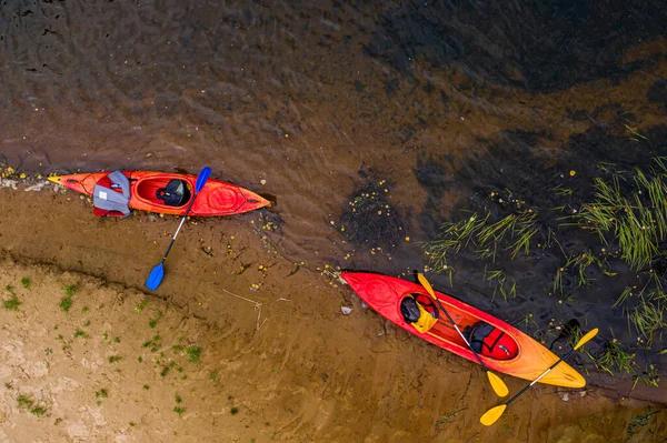 Nehir kıyısında çok renkli boş kanolar, tepeden aşağı görünüm