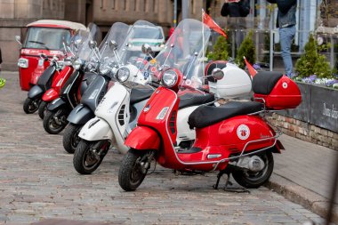 RIGA, LATVIA - 4 Mayıs 2019: Şehrin merkez meydanına park edilmiş klasik Vespa scooter sırası
