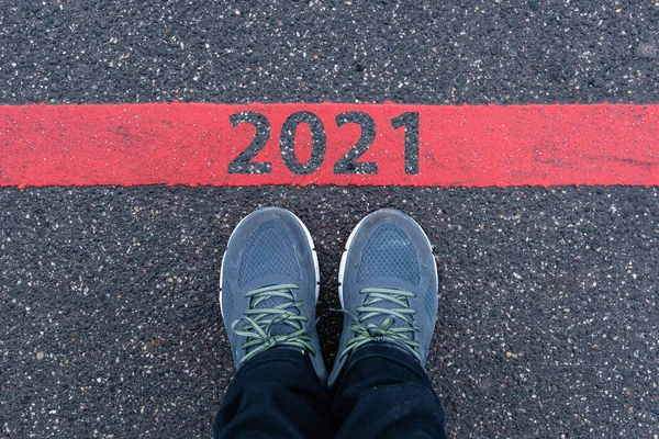 Bovenaanzicht Van Mannelijke Sneakers Asfaltweg Met Tekst 2021 Rode Lijn — Stockfoto