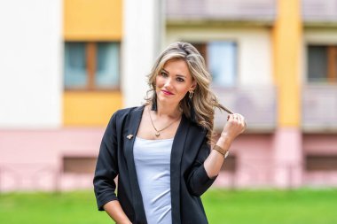 Bulanık şehir arka planına karşı genç, pozitif, zarif bir iş kadınının portresi.