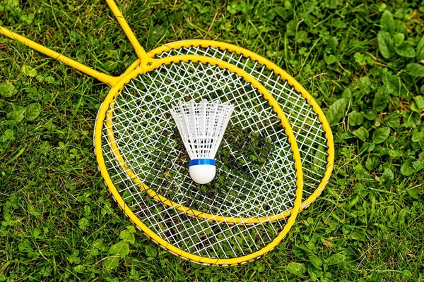 Vit Skyttel Närbild Gula Badminton Racketar Det Gröna Gräset Uppifrån — Stockfoto