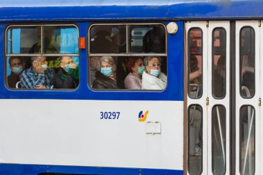 Riga, Letonya - 8 Ekim 2020: Toplu taşımacılık, koronavirüs koruma konsepti pencerelerinde yüzlerinde tıbbi maske olan insanlar