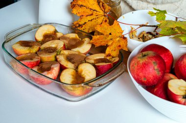 Tarçınlı kızarmış elma ve renkli sonbahar yapraklarıyla süslenmiş bal, ev yapımı çöl kavramı.