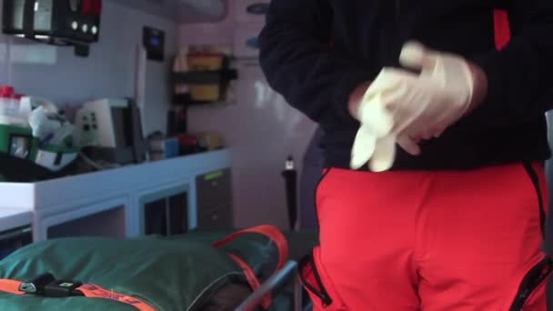 Enfermera de la ambulancia poniéndose los guantes — Vídeos de Stock