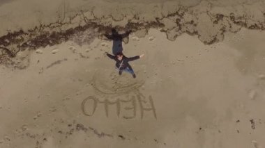 sahilde bir drone ile filme sahilde merhaba yazıyor kız