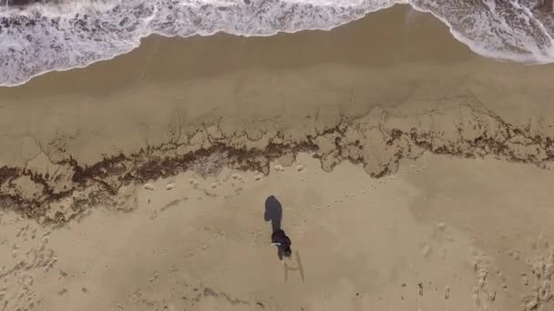 Flicka på stranden som skriver Hej på stranden filmade med en drönare — Stockvideo