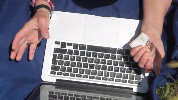 Mãos contando notas em um laptop — Vídeo de Stock