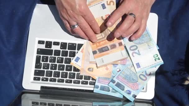 Wijzers tellen bankbiljetten op een laptop — Stockvideo