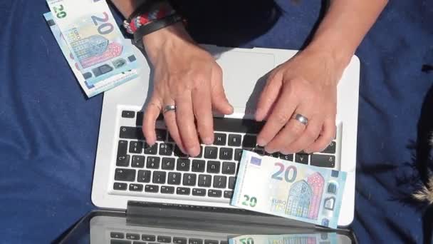 Руки, считая банкноты на ноутбуке — стоковое видео