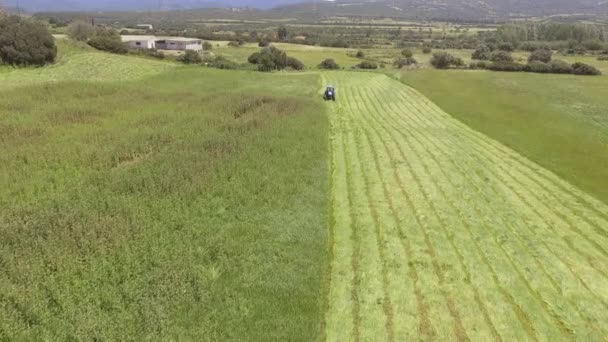 2tractor segadora en funcionamiento que corta la hierba en el campo de la agricultura — Vídeo de stock